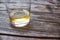 Close-up of a glass tumbler of whiskey on a wooden table