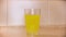 Close up of glass of water and a effervescent tablet, close up. Concept. Round yellow painkiller pill, medical concept
