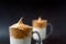 Close up of glasses of dalgona coffee with milk on the dark background.