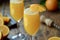 Close-up of glasses with refreshing cocktail of orange juice and champagne on wooden table,classic mimosa cocktail