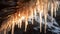 Close up of glinting Icicles hanging in the Entrance of a Cave. Natural Winter Background