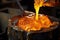 close-up of glowing molten metal being poured into a mold