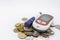 Close up of Glucode meter with lancet for check blood sugar level on pile of coins on white background. Money, Medicine, diabetes