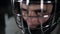 Close-up goalie hockey player in protective helmet looking at the camera. The face of the goalkeeper in anticipation of