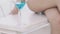 Close up goblet of blue cocktail near bare woman\'s legs and hand. Slowly