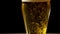 Close-up of goblets with pouring beer on black background