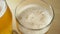 Close-up of goblets with pouring beer on black background