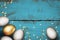 Close up of gold white easter eggs on painted wooden blue background. Brushed grunge background. Easter eggs with golden confetti