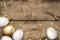 Close up of gold and white easter eggs on wooden background. Rustic grunge background. Easter eggs and golden serpentine confetti