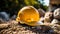 Close up of a gold Working Helmet on Gravel. Blurred Construction Site Background