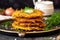 close up of golden brown latkes stacked on a serving dish