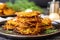 close up of golden brown latkes stacked on a serving dish