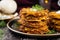 close up of golden brown latkes stacked on a serving dish