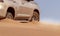 Close up of a golden car stuck in the sand in the Namib desert