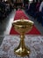 Close up of a golden chalice before mass with a red carpet in the background communion cup