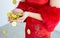 Close up on golden coins on hands of a woman wearing red qipao or dress to celebrate Chinese New Year, presenting about wealthy