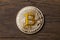 Close up of golden cryptocurrency yellow bitcoin on wooden backg