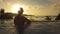 CLOSE UP: Golden evening sun rays shine on tourist enjoying in infinity pool.