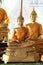 Close-up of golden meditating buddha statues