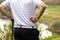 Close up of golfer holding golf ball and golf tee with golf course out of focus