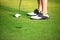 Close up golfer legs approach golf ball  putting on the green,