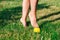 close-up of graceful bare feet of young woman standing on tiptoes on spiked massage ball on green lawn of courtyard