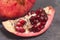 Close up Granate Seeds in slice. Pomegranate Slice Fruit. diet, vitamine and Health concept. Gray board.