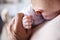 Close up of grandfather holding the hand of his baby grandson as he holds him, detail, elevated view