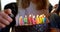 Close-up of grandfather lighting candles on birthday cake 4k