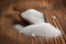 Close-up of granulated white sugar in a scoop on a wooden rustic background. Front view