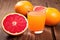 close-up of grapefruit halves next to a glass of juice