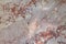 close up of gray and light pinkish with rust color spots patterned marble stone wall background