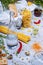 Close-up of a gray table with pasta, baguette, glass bottle, chili pepper, quail eggs and walnuts on a gray background.