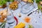 Close-up of a gray table with pasta, a bottle, red chili pepper, walnuts, olives, asparagus on a light gray background.