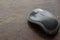 Close-up of a gray wireless computer mouse on a wooden surface