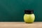 Close-up Of A Green Apple With Graduation Hat