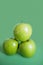 Close-up of green apples in pyramid stack over colored background