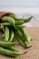 Close-up of green beans on burlap, in the background defocused beans on white background