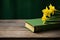 Close-up green book and a vibrant yellow daffodil on a rustic wooden table Generative AI