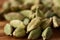 Close-up of green cardamon seeds on rustic wooden background, top view, selective focus, macro.