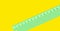A close up of a green desk rule. Isolated element on yellow background.