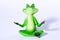Close up of green frog figure doing yoga meditation