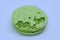 The close up of green macaron with broken crusty shell.