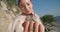 Close-up green mantis on female Caucasian hand with blurred young woman smiling at background. Insect in sunshine