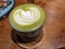 Close up green matcha latte over the wooden table on the cafÃ© and resto