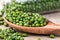 Close up green mung beans in wooden spoon on wood plate