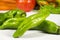Close-up of green peppers. Other vegetables at background