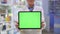 Close-up green screen web page template in hands of unrecognizable senior pharmacist advertising app standing in
