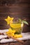 Close-up of green tea on a wooden background. Sweet tasty tea with decorative carambola, mint leaves, and cinnamon. Copy space.