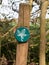 close up green and white leaf wooden sign on post details